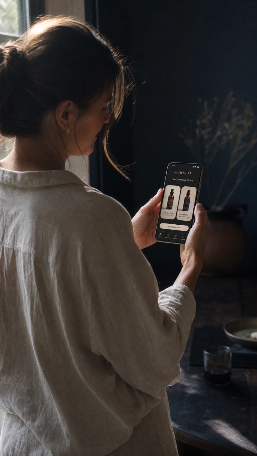 A brand founder holding her phone, using the mobile app built for her
